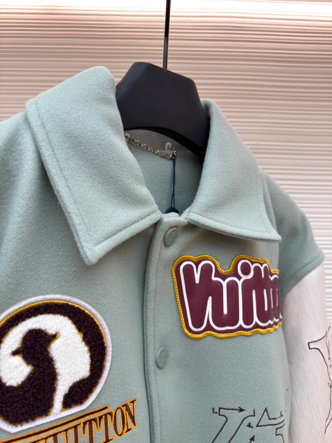 LOUIS VUITTON letter pattern patch printed color block baseball jersey ●Original version: 38999 purchase and development ●Item number: 1681672-D15 ●Fabric: sheep wool fabric ●Technology: printing production ●Color: green ●Version: fitted version ●Weight: about 1220 grams ●Size: 46-48-50-52 ●Description: This jacket is made of high-quality wool blended fabric, which is soft to the touch and has excellent warmth retention. The overall design adopts a lapel design, and the collar, cuffs and hem are all ribbed, with moderate elasticity, comfortable to wear and not easy to deform. The main part uses multi-color splicing technology. The gray and white splicing lines are smooth and natural, showing superb tailoring technology. The patterns on the chest and sleeves are embroidered and appliquéd, with distinct layers and a strong three-dimensional effect. Multi-colored silk threads are interwoven during the embroidery process to ensure that the pattern is clear and durable. The buttons of the jacket are made of metal, with a smooth surface and not easy to fade. The splicing of the shoulders and sleeves adopts seamless technology, with smooth and natural lines without excess threads. The overall workmanship is fine, and every stitch is even and neat, reflecting the high-quality production process. The overall wiring is straight and delicate, the fabric is comfortable and soft, and the color is consistent without color difference. It can be matched with the same style to create a fashionable look and control various occasions. Customized accessories, complete with three standards, same style for men and women!